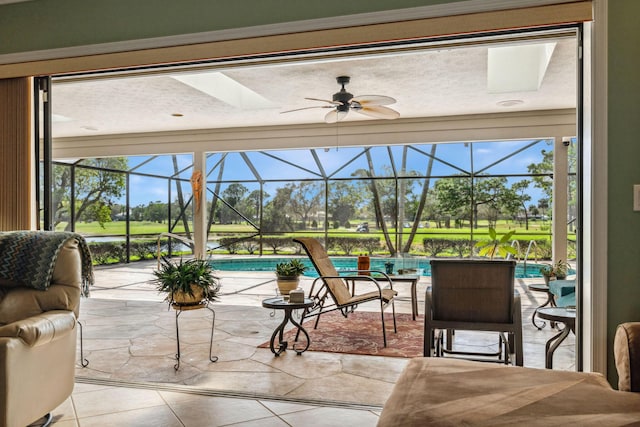 sunroom / solarium featuring a ceiling fan