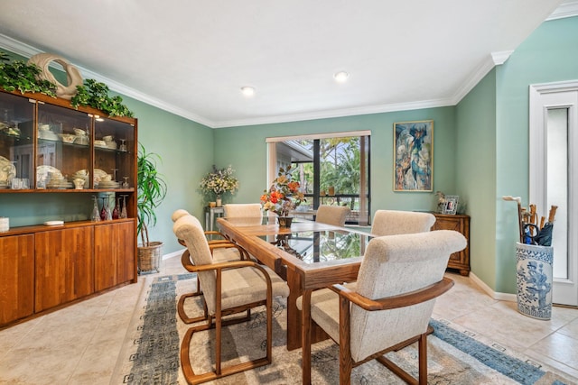 dining space featuring light tile patterned floors, baseboards, and ornamental molding