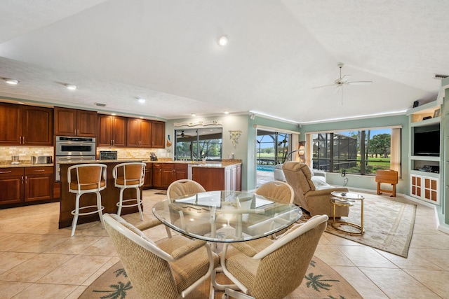 dining area with lofted ceiling, a healthy amount of sunlight, recessed lighting, and light tile patterned floors