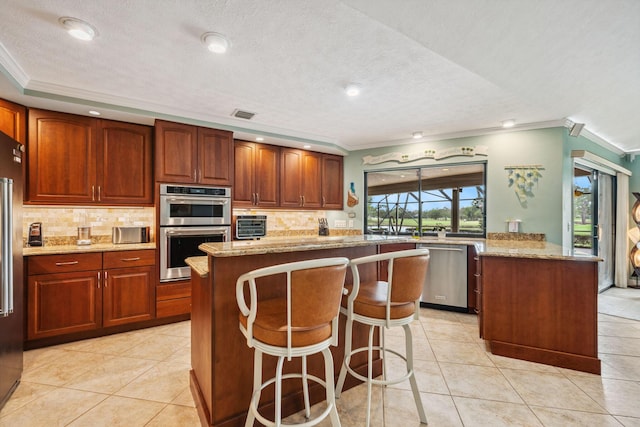 kitchen featuring appliances with stainless steel finishes, light stone countertops, backsplash, and light tile patterned floors