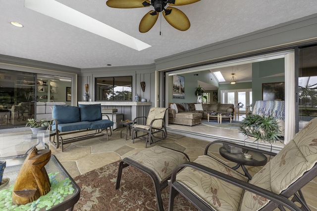 sunroom with french doors, a skylight, and a ceiling fan