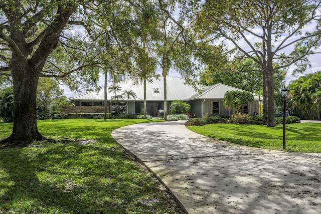 view of home's community featuring concrete driveway and a yard