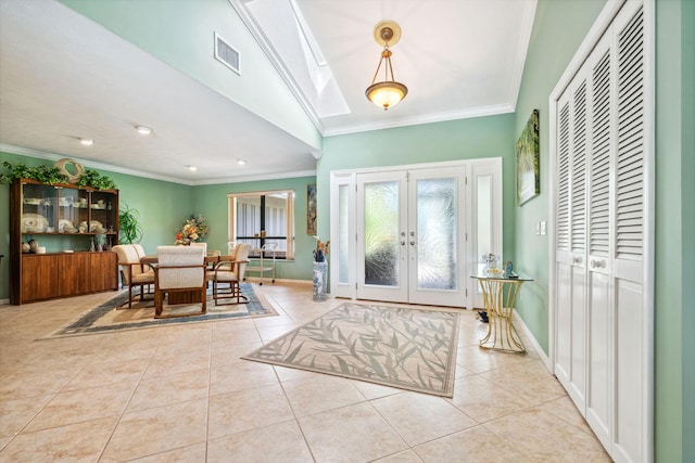 tiled foyer with ornamental molding, french doors, visible vents, and baseboards