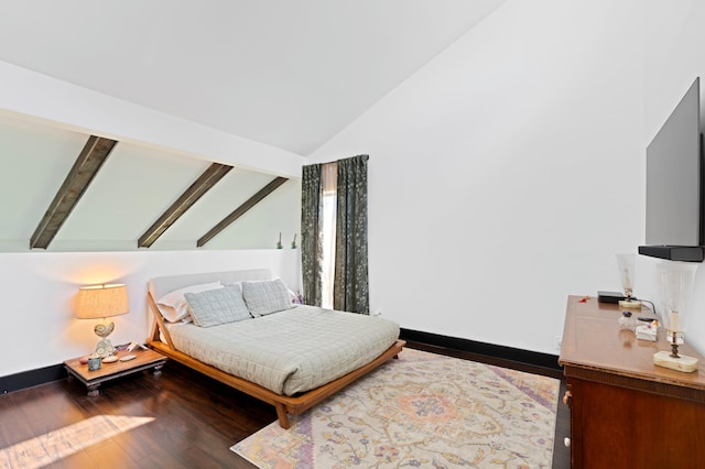 bedroom featuring lofted ceiling with beams, wood finished floors, and baseboards