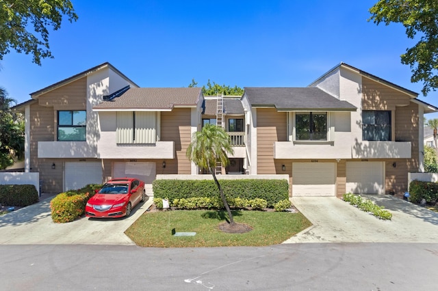 multi unit property featuring a garage and driveway