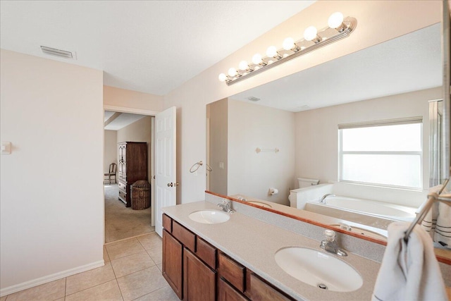 ensuite bathroom featuring a garden tub, tile patterned flooring, a sink, and visible vents