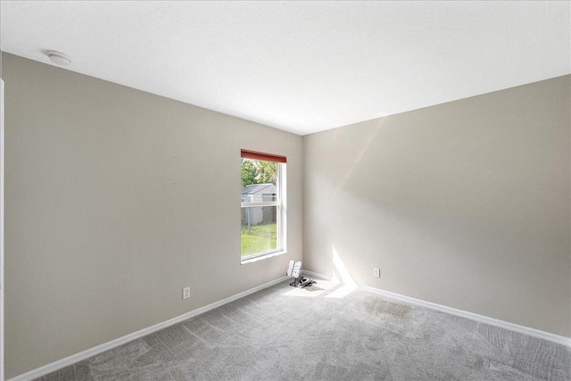 carpeted empty room with baseboards