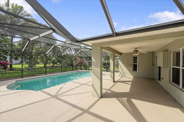 outdoor pool with a lanai, a patio area, and a ceiling fan