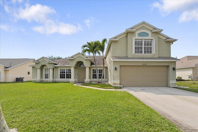 view of front of house featuring stucco siding, a front yard, a garage, cooling unit, and driveway