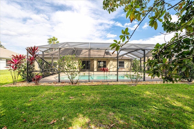 pool featuring glass enclosure and a yard