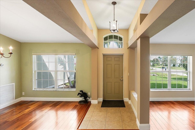 foyer with light wood finished floors, visible vents, and baseboards