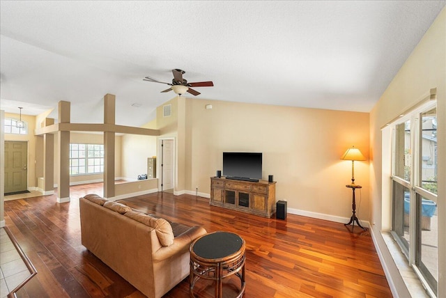 living area featuring visible vents, baseboards, lofted ceiling, wood finished floors, and ceiling fan with notable chandelier