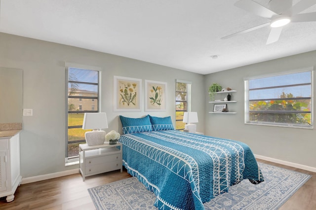 bedroom with wood finished floors, baseboards, and ceiling fan