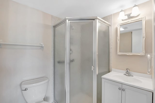 bathroom with a shower stall, vanity, and toilet