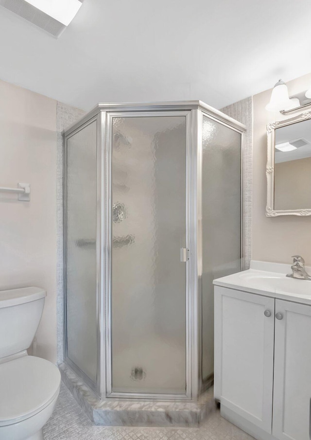 bathroom featuring vanity, toilet, and a shower stall