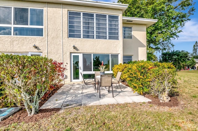 back of property with a patio area and stucco siding