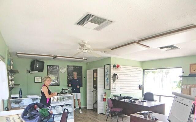 office space with wood finished floors, a ceiling fan, and visible vents