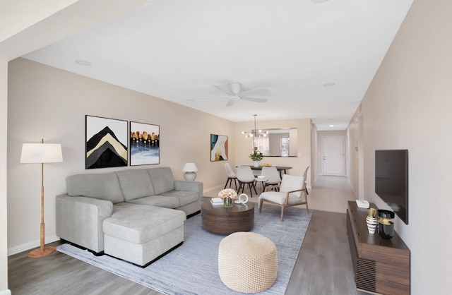 living area with a notable chandelier, baseboards, and light wood-style floors