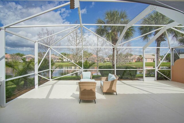 view of patio / terrace with glass enclosure and a water view