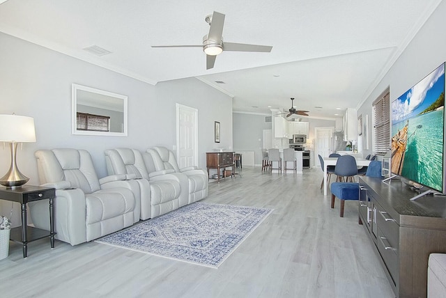 living room with ceiling fan, ornamental molding, visible vents, and light wood-style floors