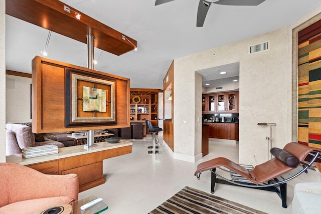 living room featuring baseboards, light tile patterned flooring, visible vents, and a ceiling fan