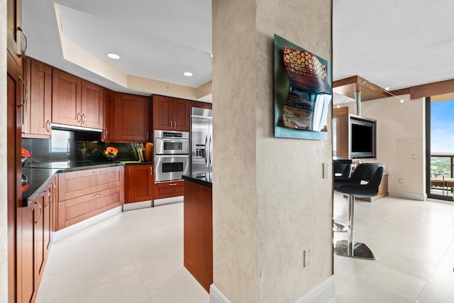 kitchen with baseboards, decorative backsplash, dark countertops, stainless steel appliances, and recessed lighting