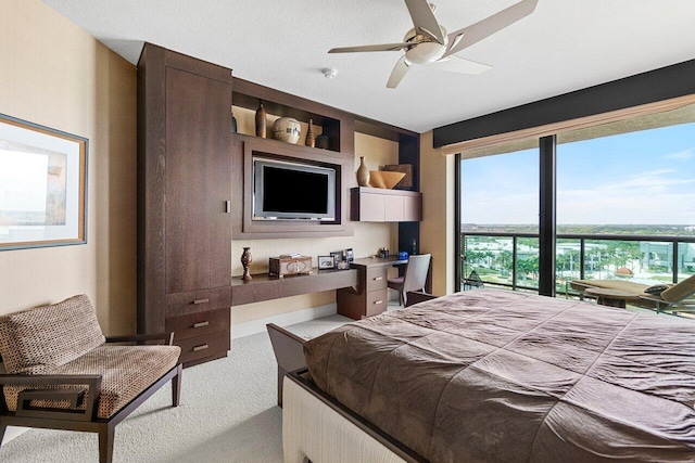 carpeted bedroom with ceiling fan and built in study area