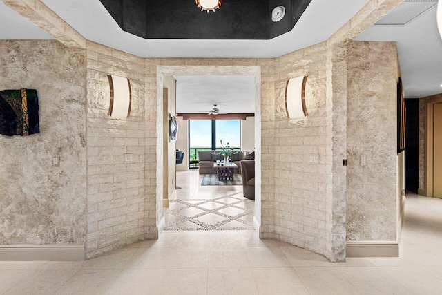 hall featuring baseboards and tile patterned floors