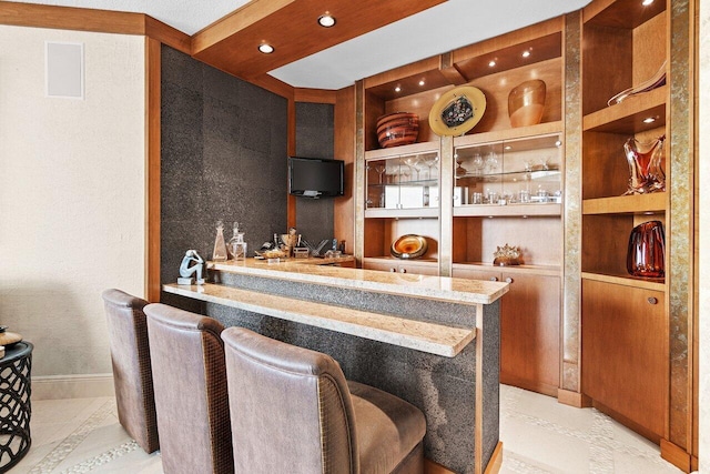 kitchen with built in features, a breakfast bar area, open shelves, recessed lighting, and baseboards