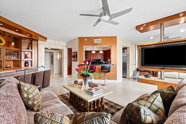 living area featuring a ceiling fan and visible vents