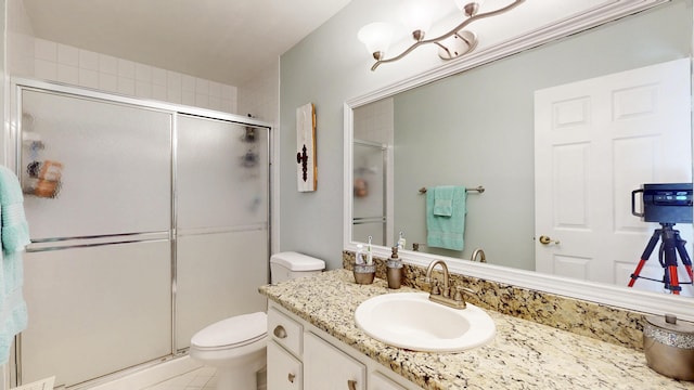 full bathroom featuring a shower stall, toilet, and vanity