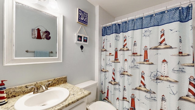 bathroom featuring a shower with shower curtain, vanity, and toilet