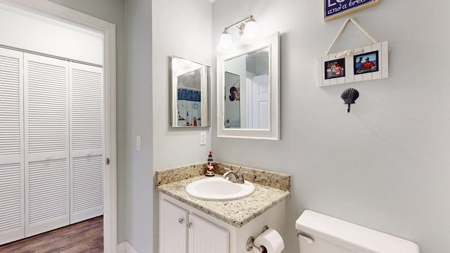 bathroom featuring wood finished floors, vanity, and toilet