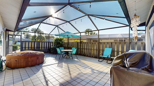 view of patio with glass enclosure, outdoor dining space, grilling area, and a hot tub