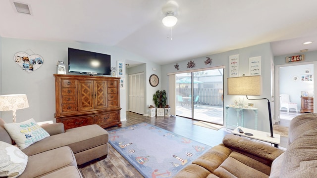 living room with visible vents, vaulted ceiling, and wood finished floors