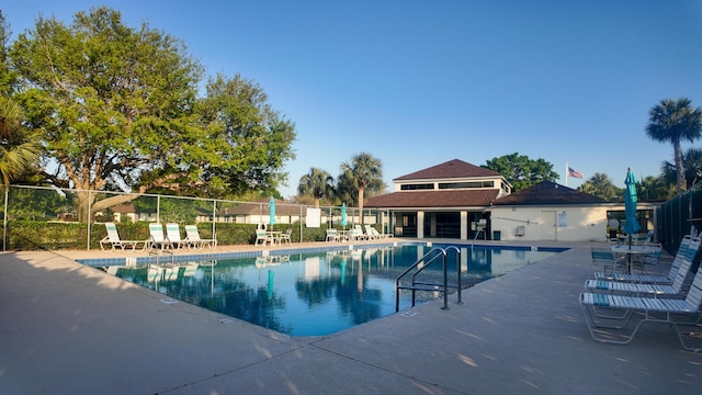 pool featuring a patio area and fence