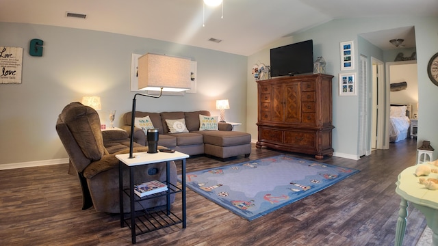 living room with vaulted ceiling, wood finished floors, visible vents, and baseboards