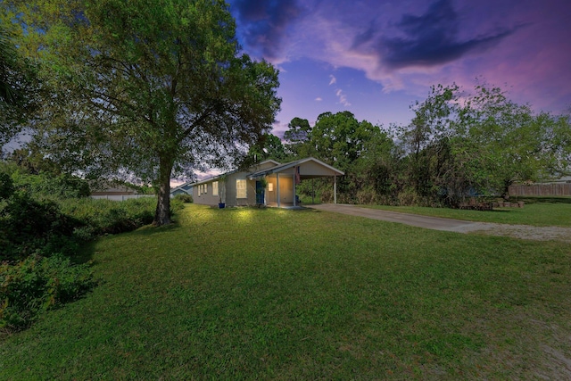 view of front facade featuring an attached carport, concrete driveway, and a lawn