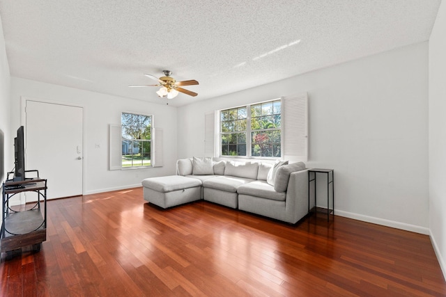 living room with hardwood / wood-style flooring, a ceiling fan, baseboards, and a textured ceiling