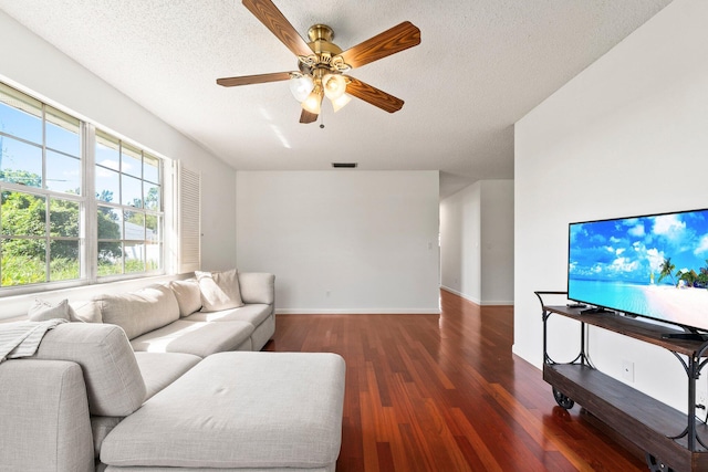 living area with a ceiling fan, a textured ceiling, visible vents, and wood finished floors