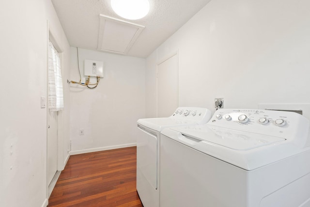 laundry area with laundry area, attic access, baseboards, wood finished floors, and independent washer and dryer