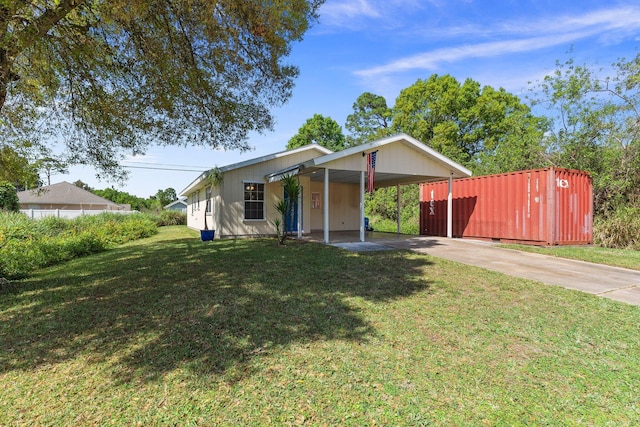 view of front of home with an attached carport, concrete driveway, and a front yard