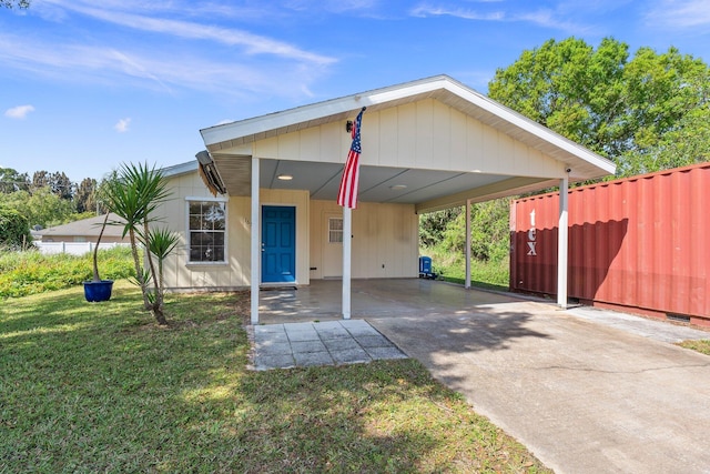 view of front of house with driveway, fence, a carport, and a front yard