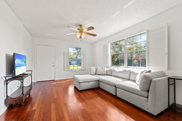 living room featuring a textured ceiling, ceiling fan, hardwood / wood-style floors, and baseboards