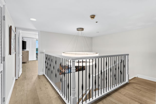 hallway with baseboards, wood finished floors, and recessed lighting