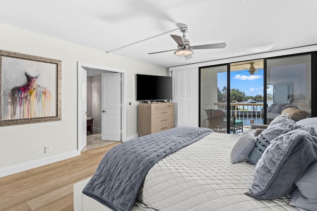 bedroom featuring light wood finished floors, baseboards, a ceiling fan, access to exterior, and floor to ceiling windows