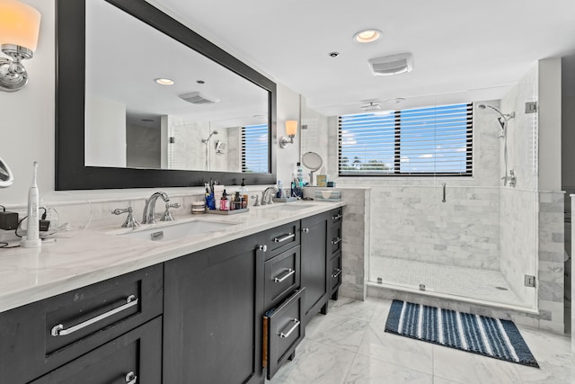 full bath with marble finish floor, a sink, a shower stall, and double vanity