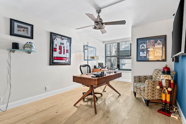 office space with baseboards, a ceiling fan, and light wood-style floors