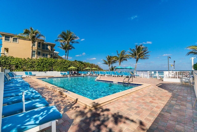 pool with a patio area and fence