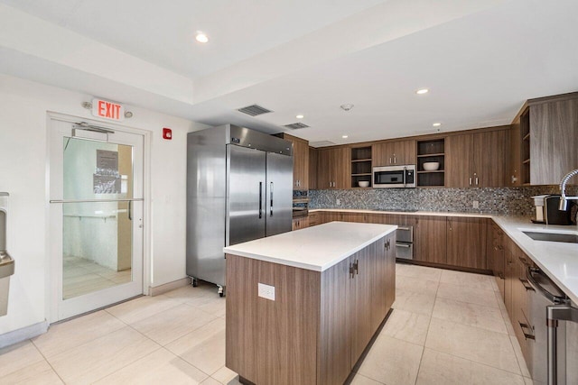 kitchen with appliances with stainless steel finishes, visible vents, decorative backsplash, and open shelves